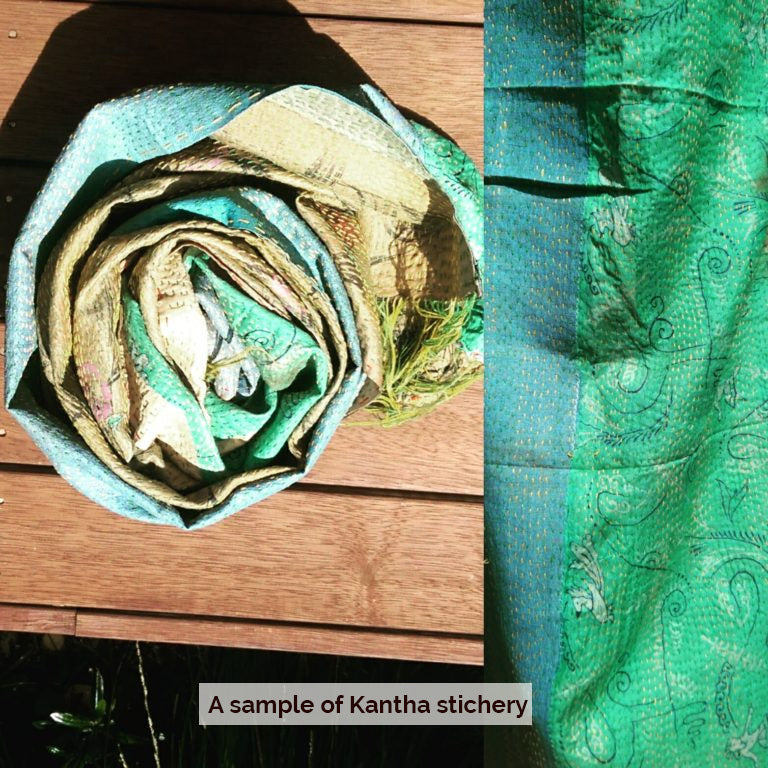 close-up of vibrant turquoise and green Kantha stitchery fabric crafted by women artisans