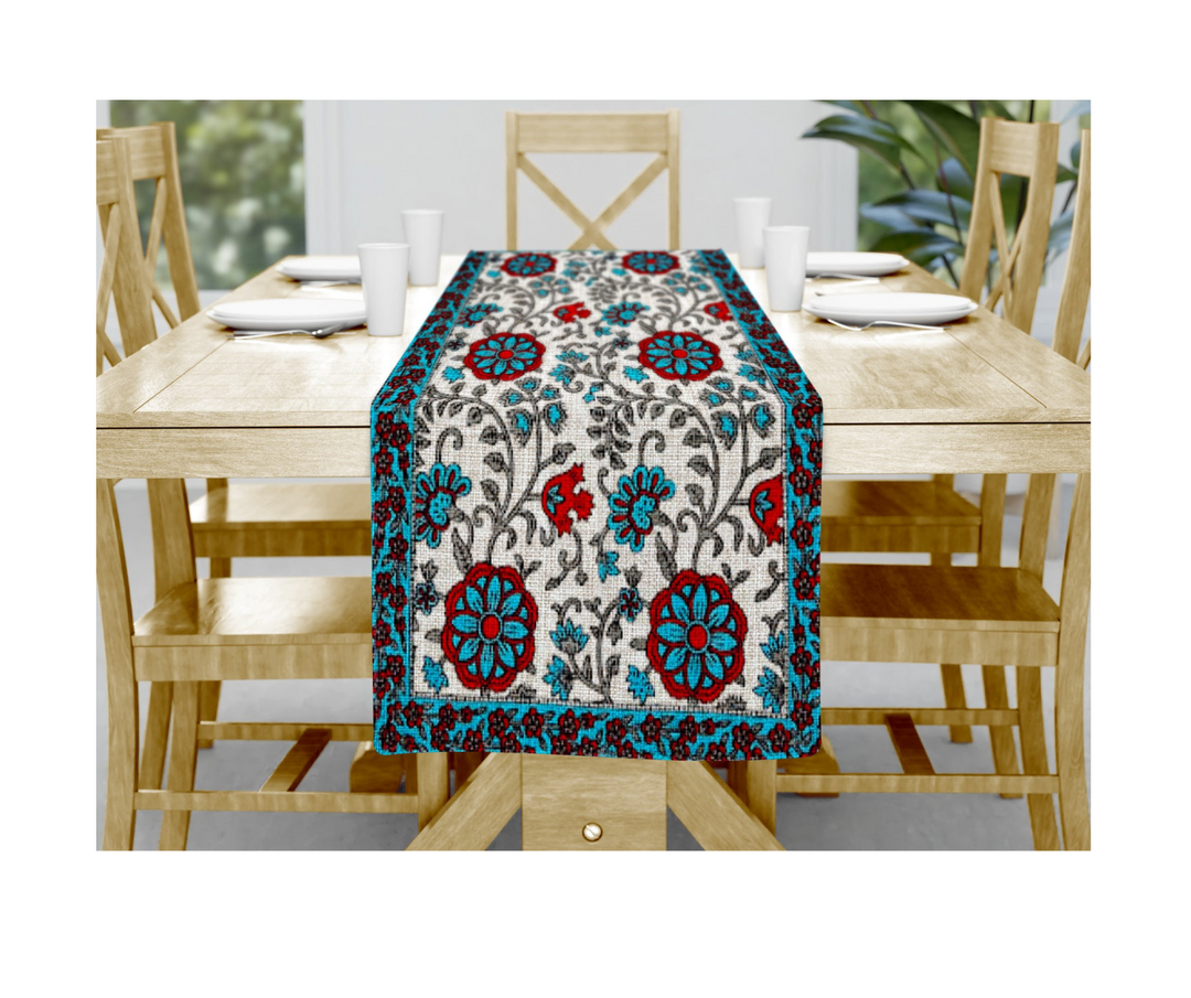 Hand block printed cotton table linen with red and blue floral patterns on wooden dining table runner